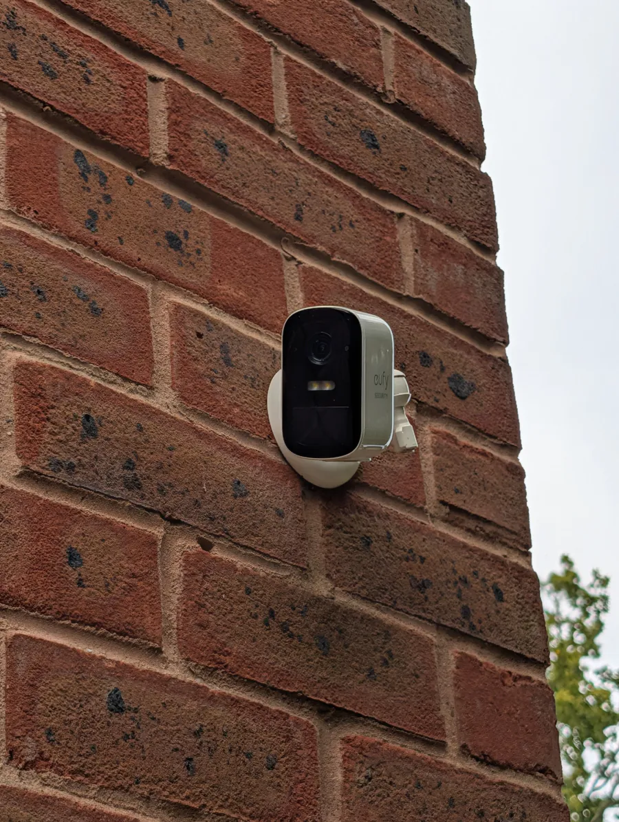 Wireless security camera mounted on a brick wall